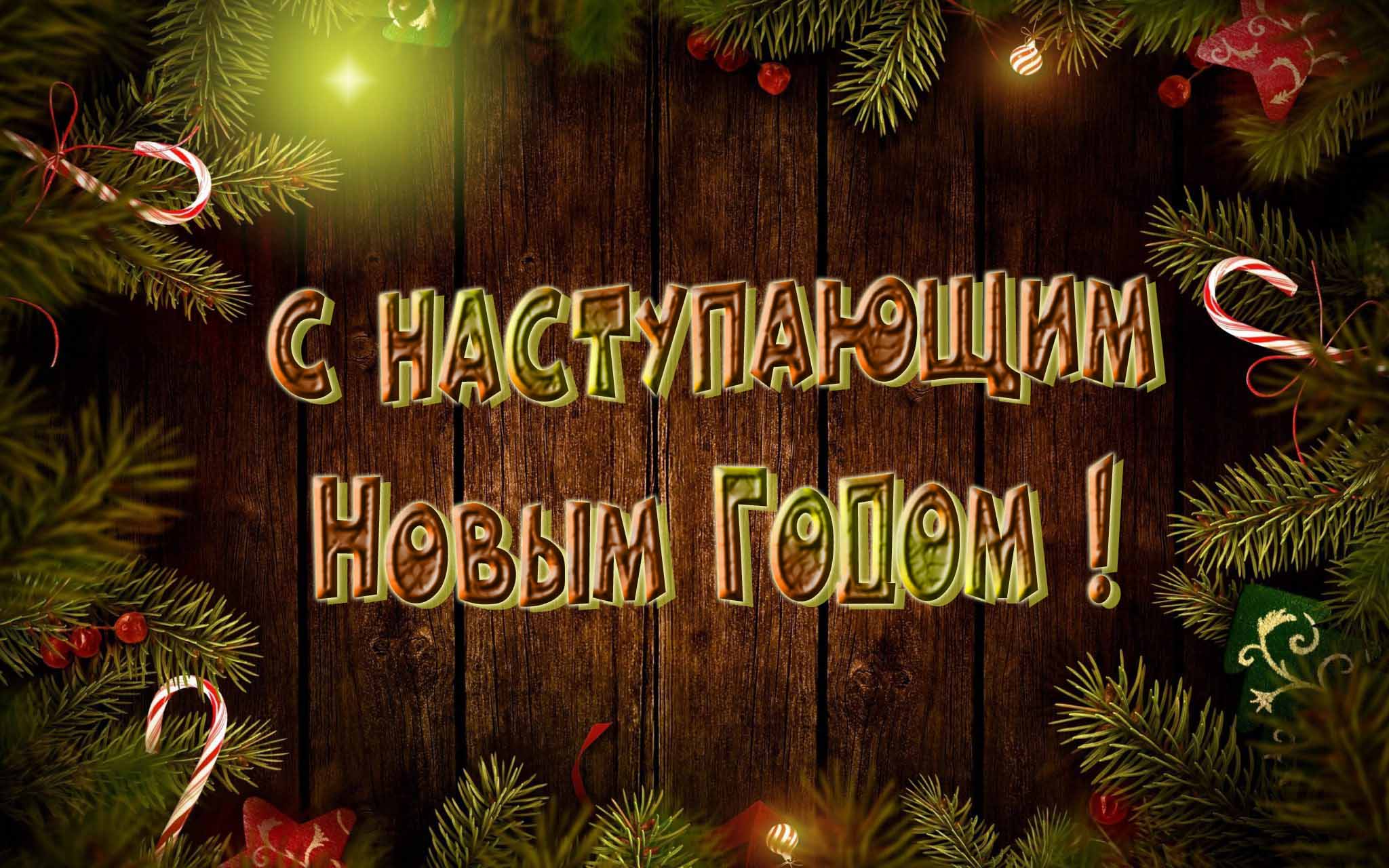 Праздничная картинка в рамке из еловых веток и надписью на деревянных досках "С наступающим Новым Годом!".